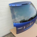 Mazda CX7 I MK1 aizmugurējā durvju apakšējā bagāžnieka vāka krāsa 34J Aurora Blue Mica